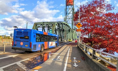 A TriMet bus crosses a bridge, with pedestrian and bike lanes on the shoulder